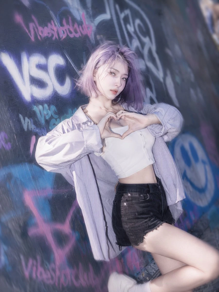紫发少女涂鸦墙前比心