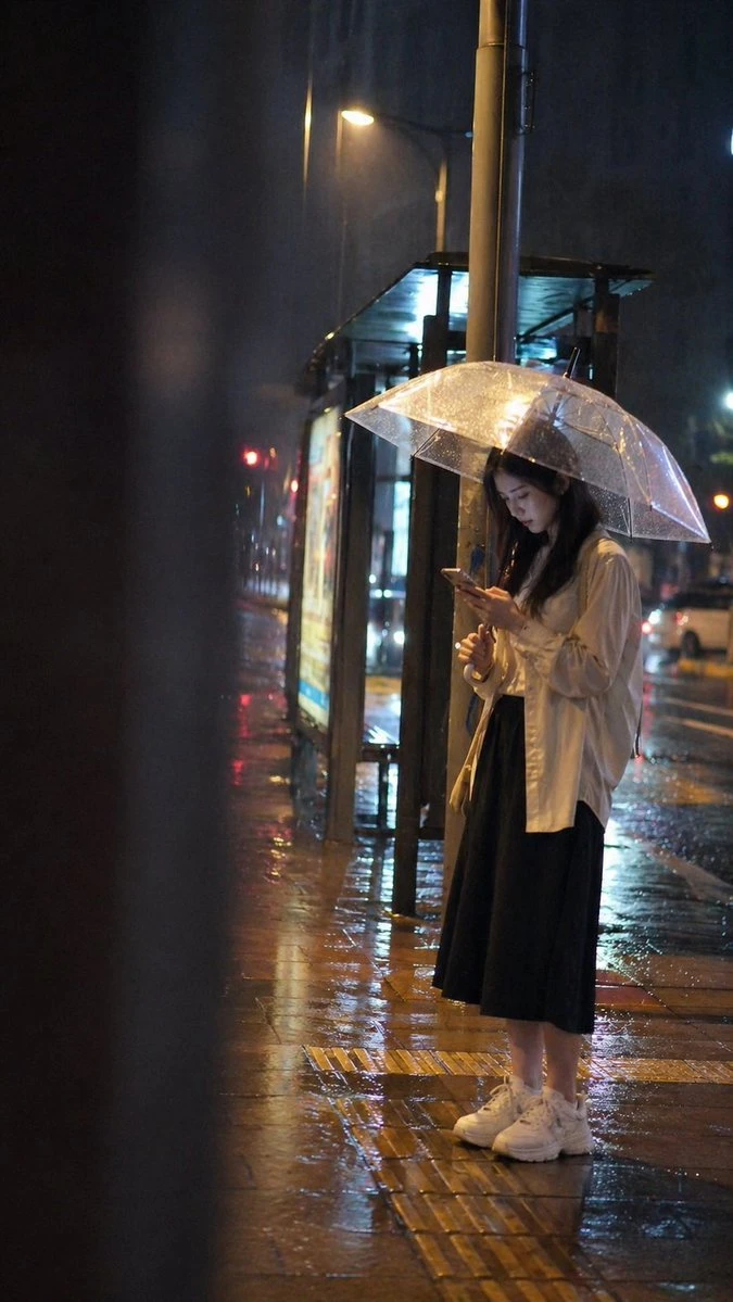 雨夜公交站女孩看手机